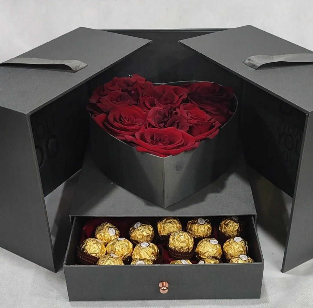 coeur caché de fleurs rouges dans une boîte noire
