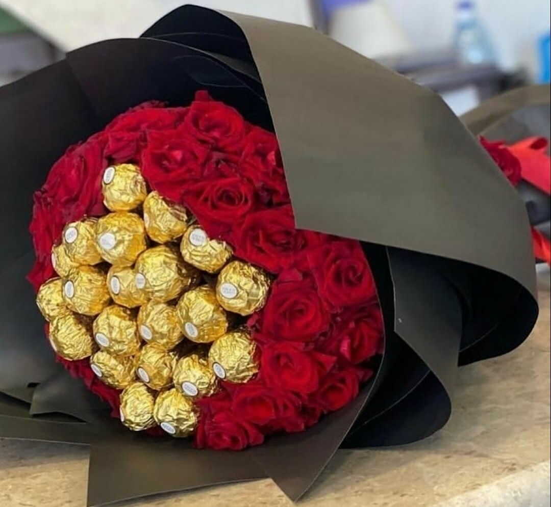 fleurs rouges en couverture noire décorées de chocolat.