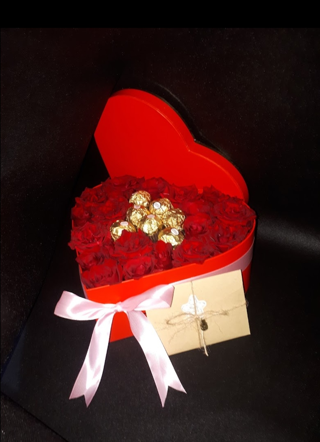 Un cadeau du Nouvel An est une boîte remplie de roses rouges et de chocolat